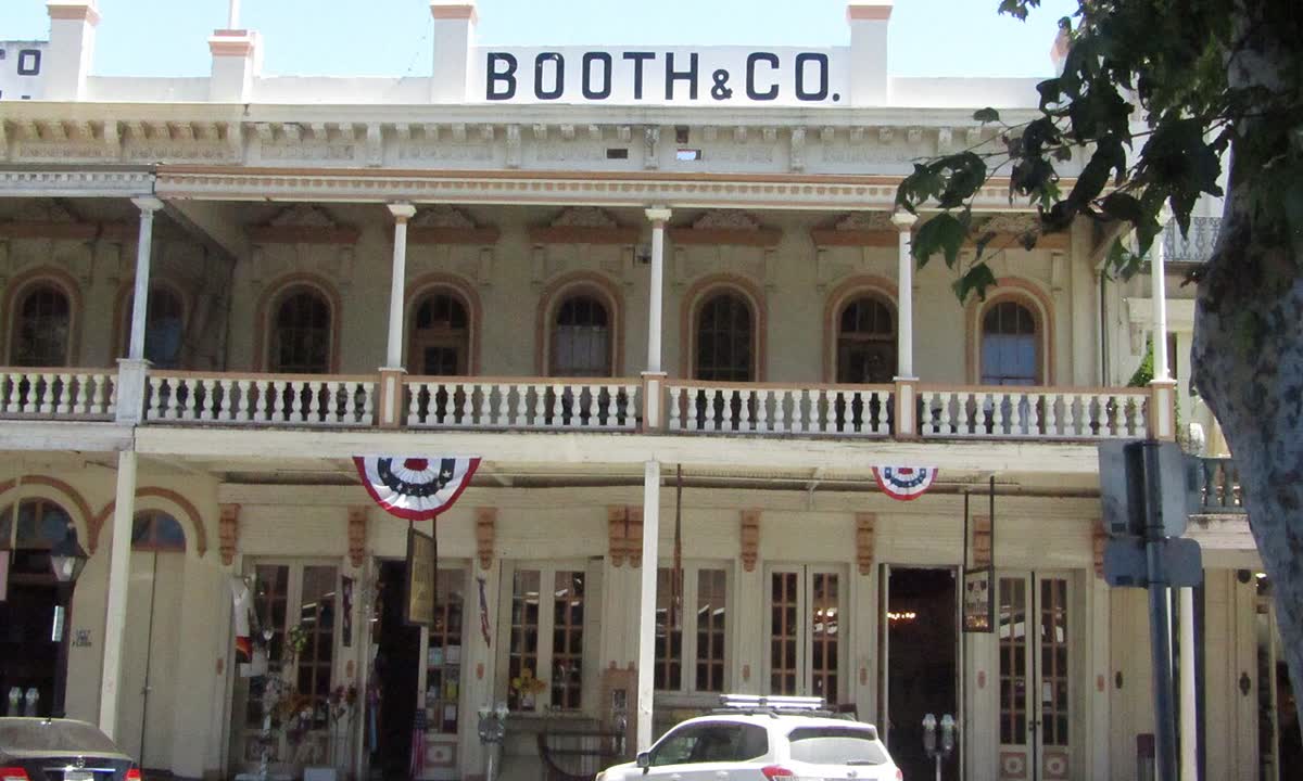 Two-story brick storefronts with balconies and flags in Old Sacramento