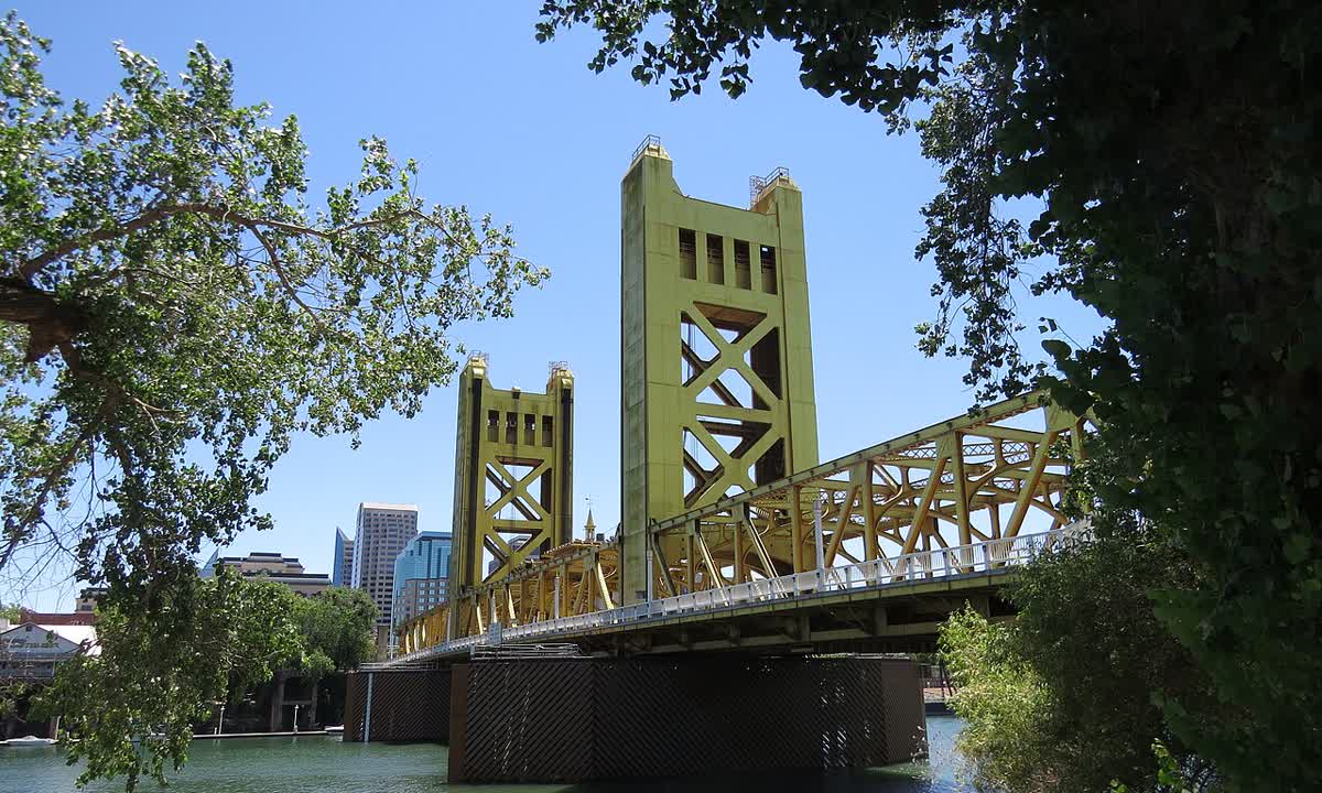Gold Tower Bridge crossing the Sacramento River, framed by trees